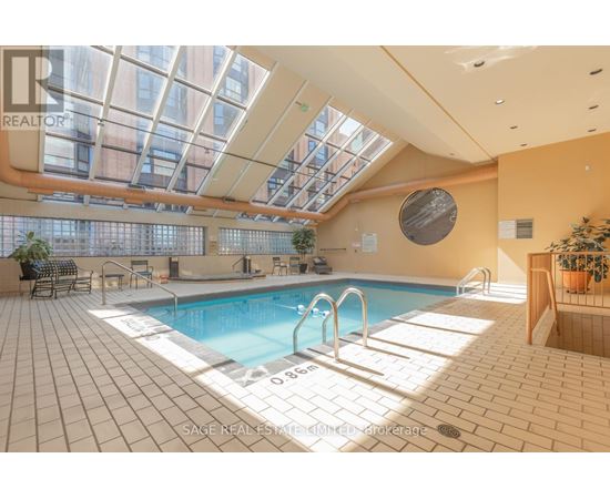A large indoor swimming pool with a glass ceiling.