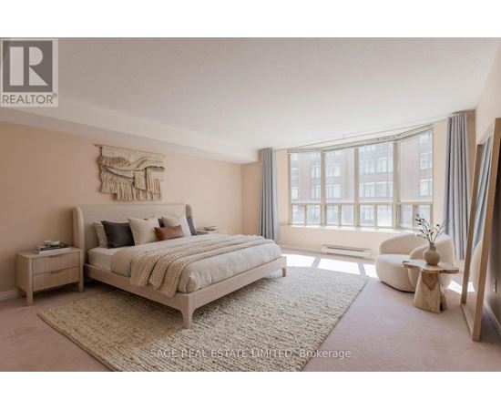 A bedroom with a large bed and a window with curtains.
