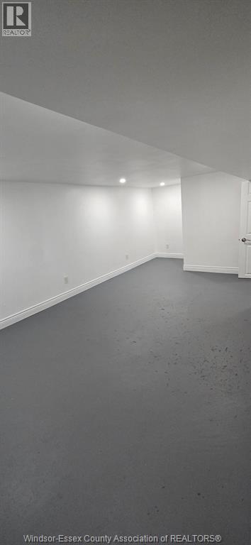 A spacious room with a white ceiling and walls.