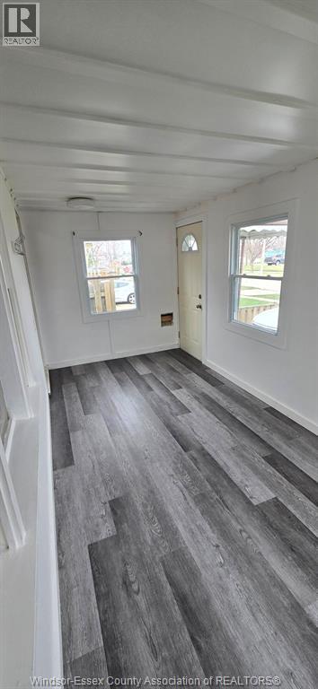 A room with a white ceiling and grey flooring.