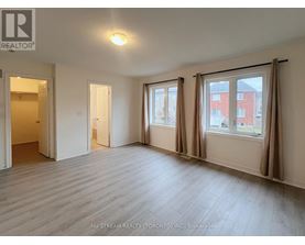 A room with a large window and a door leading to another room.