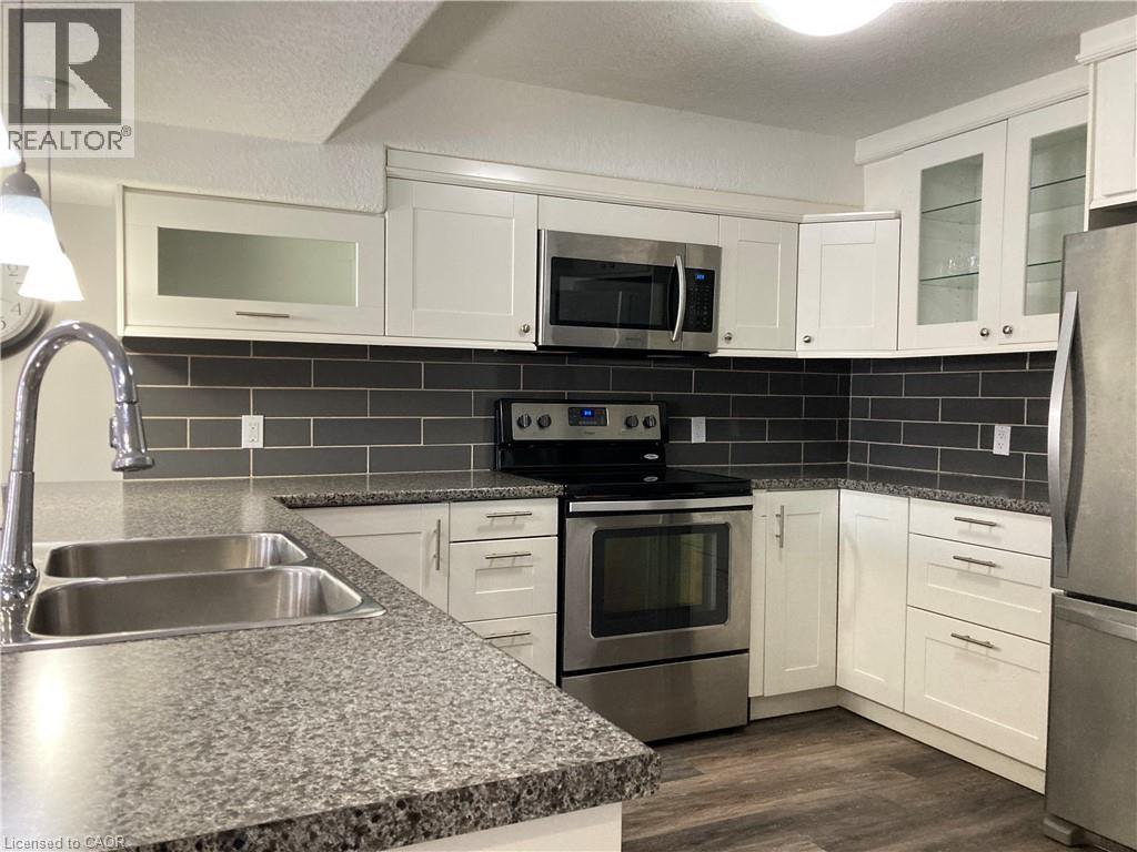 A kitchen with white cabinets and a granite countertop.