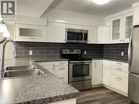 A kitchen with white cabinets and a granite countertop.