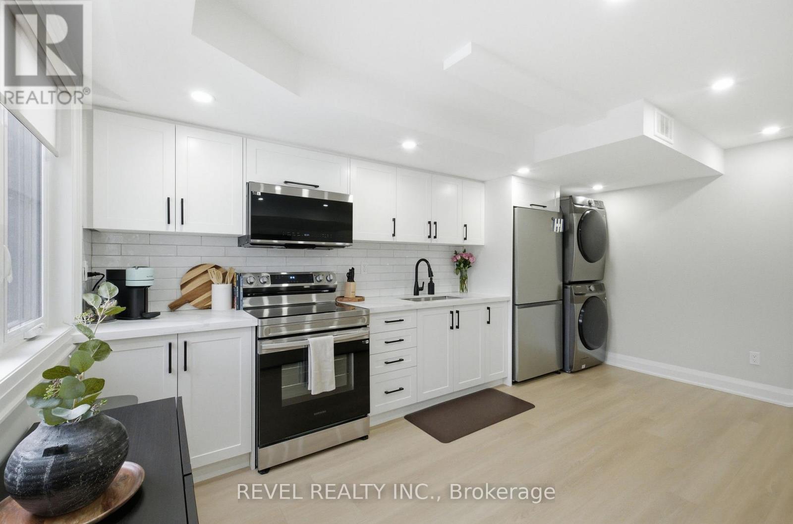 A modern kitchen with white cabinets and stainless steel appliances.