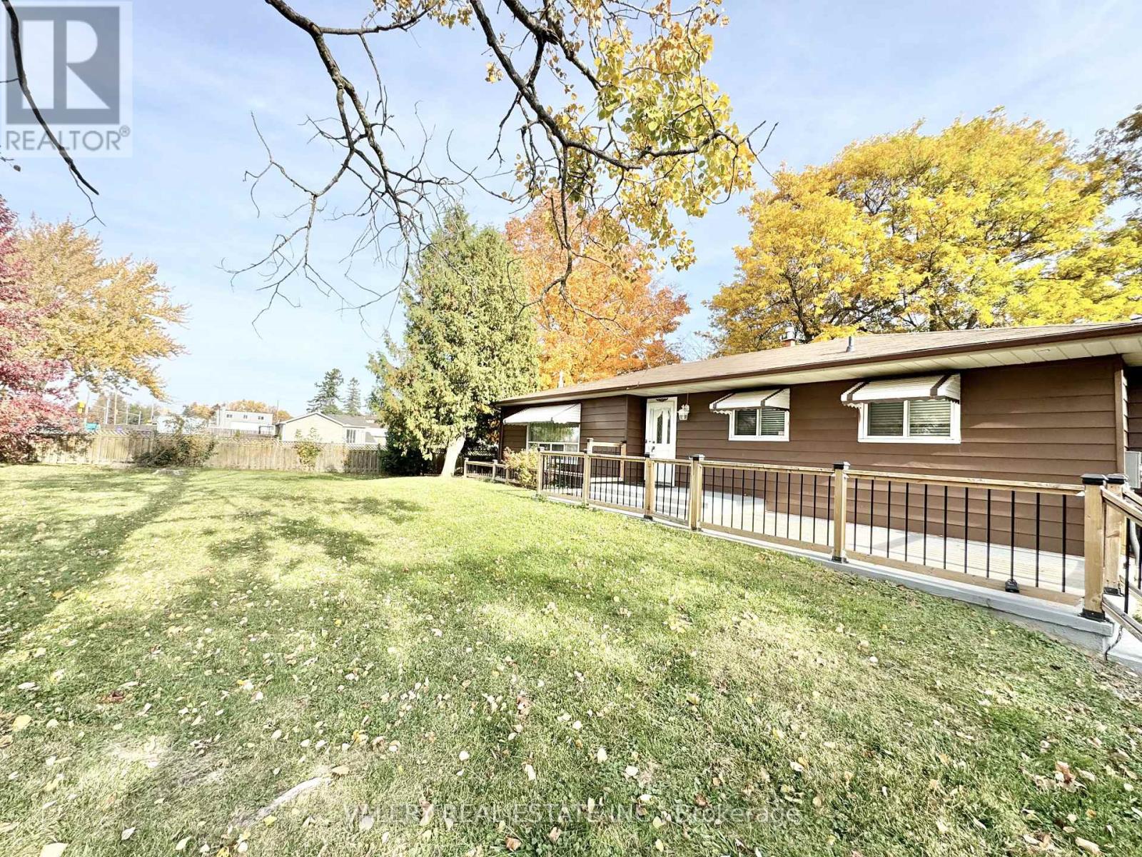 A house with a brown roof and a fence in front of it.