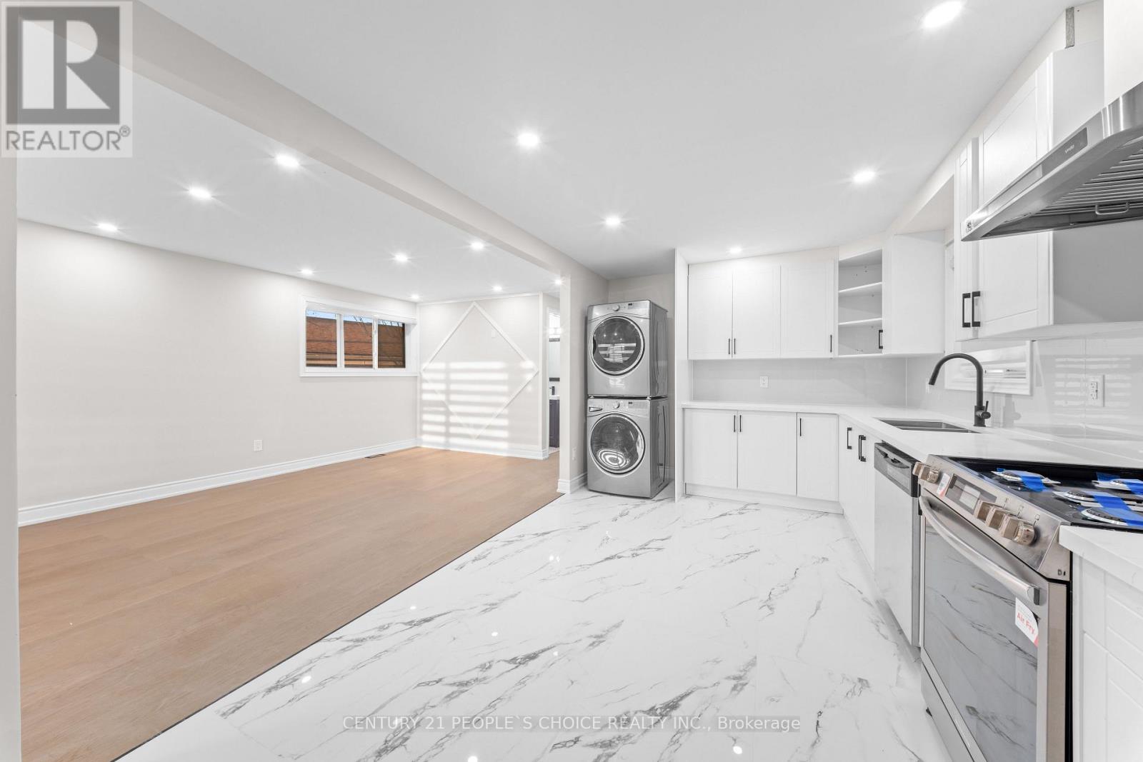 A modern kitchen with white cabinets and a marble floor.
