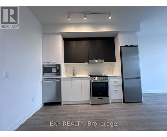 A kitchen with white cabinets and a black backsplash.