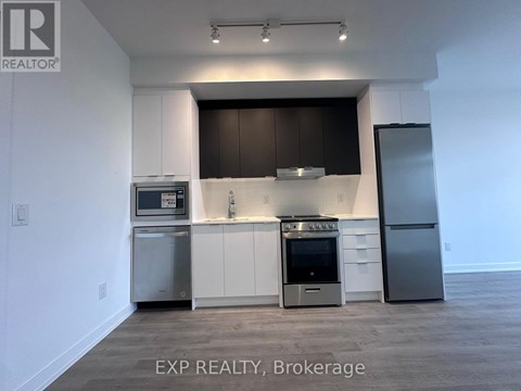 A kitchen with white cabinets and a black backsplash.