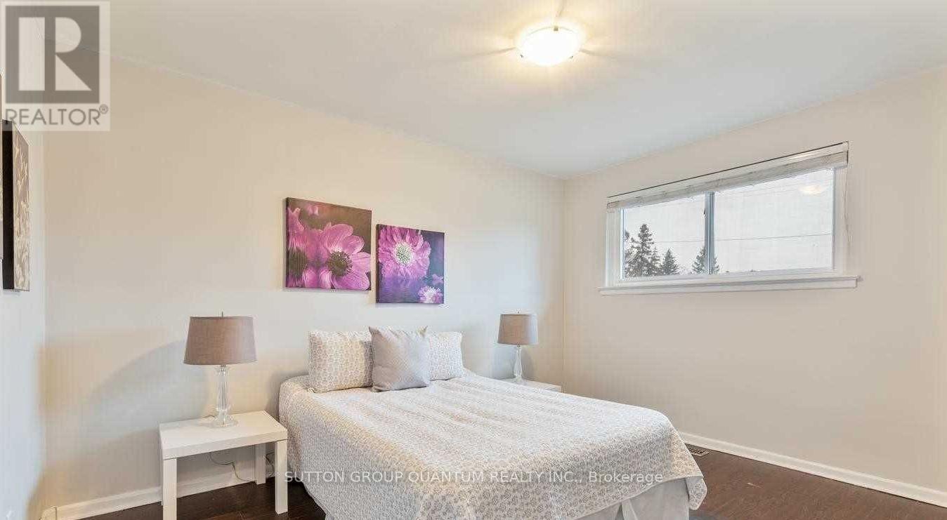 A bedroom with a bed, two lamps, and a painting on the wall.