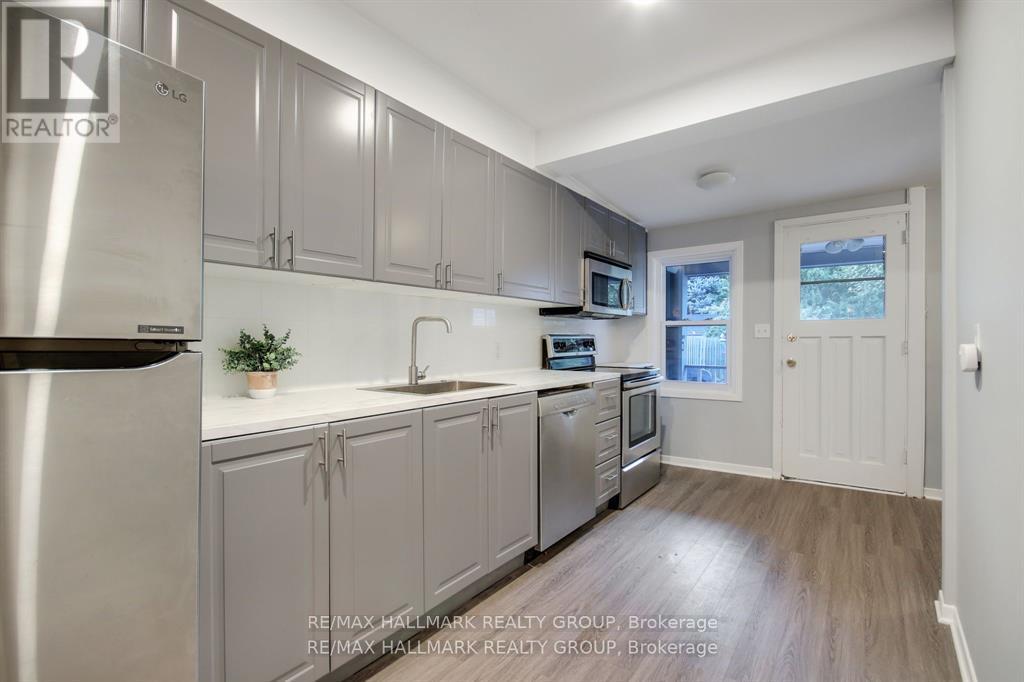 A kitchen with stainless steel appliances and white countertops.