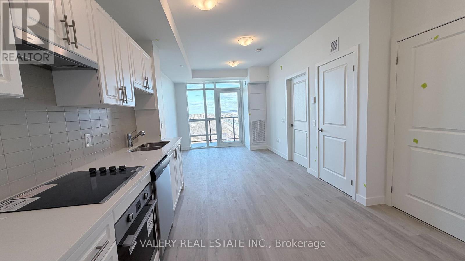 A kitchen with white cabinets and a stove top oven.