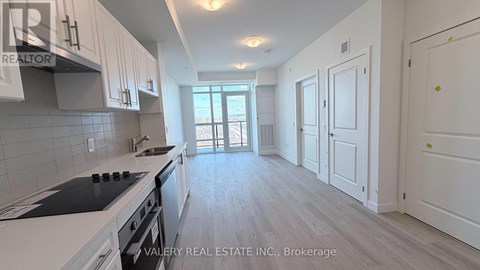 A kitchen with white cabinets and a stove top oven.