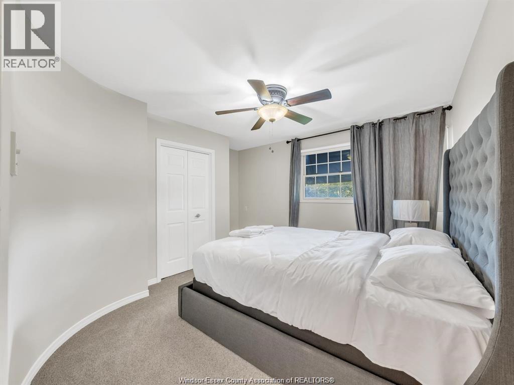 A bedroom with a large bed and a ceiling fan.