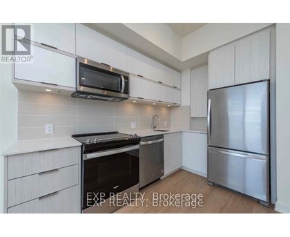 A kitchen with white cabinets and stainless steel appliances.