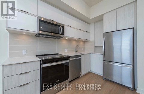 A kitchen with white cabinets and stainless steel appliances.