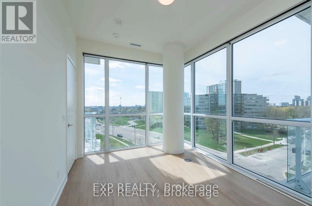 A room with a view of the cityscape through large windows.