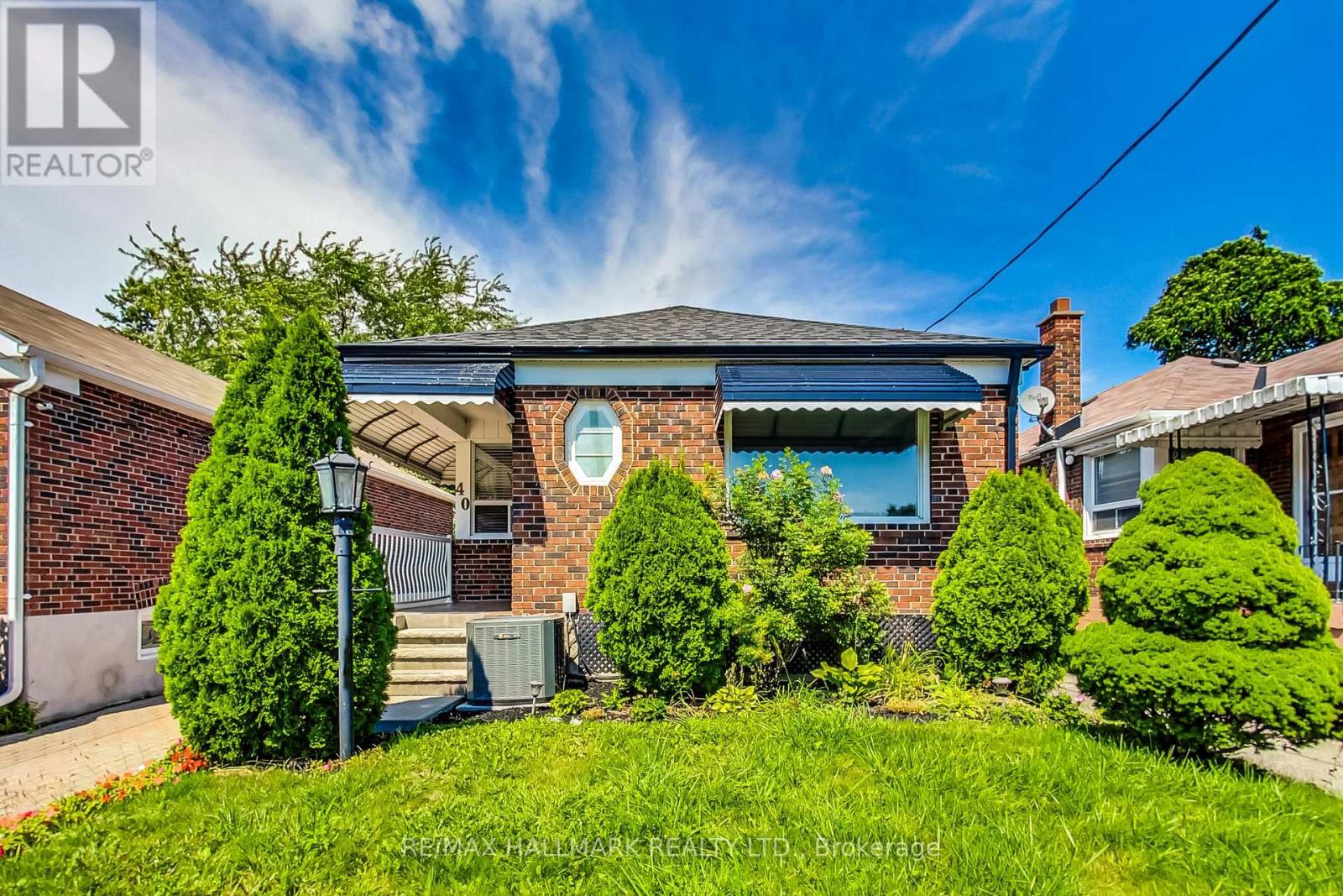 A house with a green lawn and a blue sky in the background.
