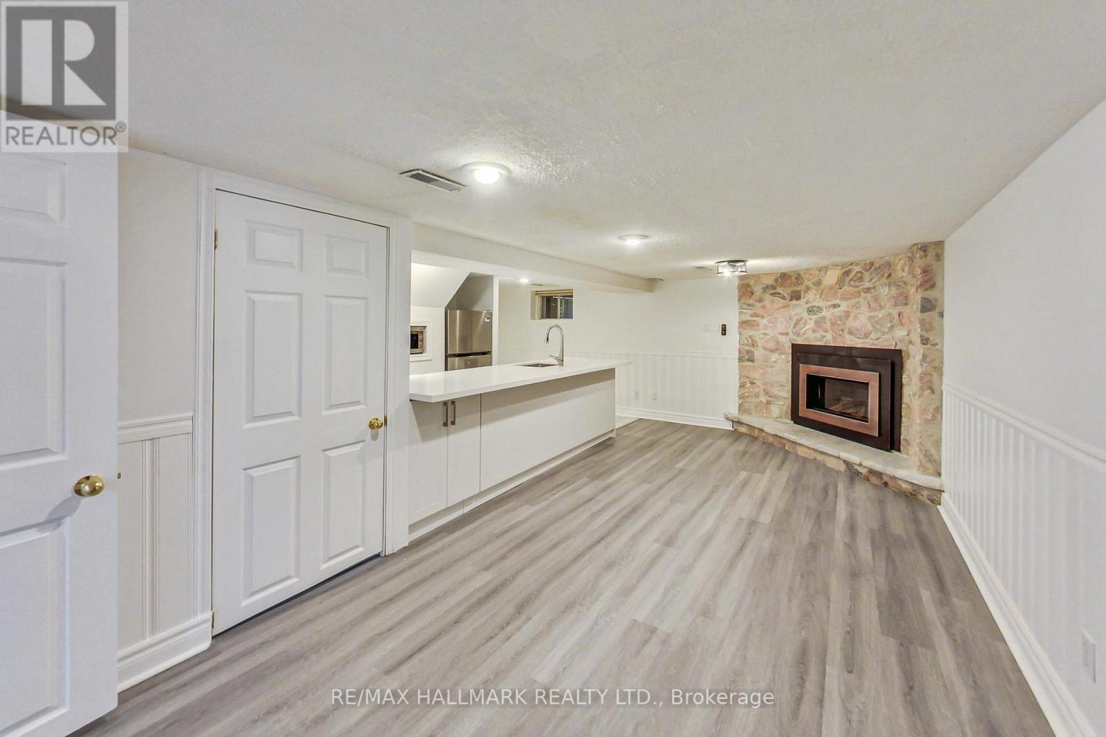 A room with a fireplace and a wooden floor.