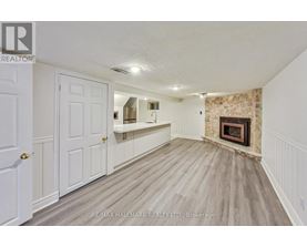 A room with a fireplace and a wooden floor.