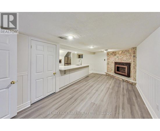 A room with a fireplace and a wooden floor.