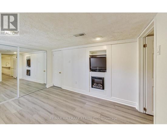A spacious living room with a television and a fireplace.