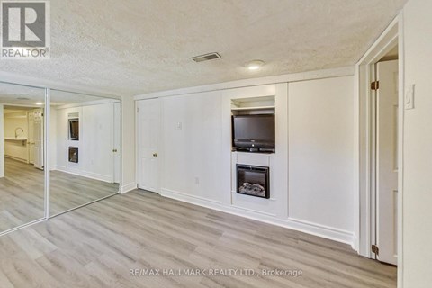 A spacious living room with a television and a fireplace.