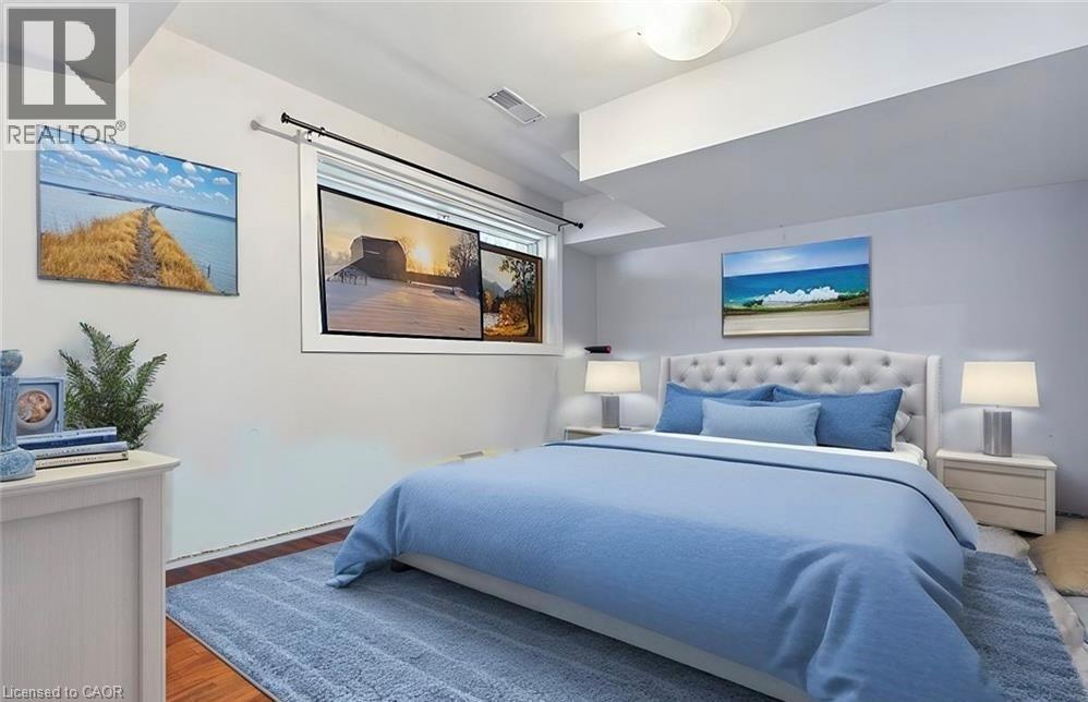 A bedroom with a large bed and pictures on the wall.