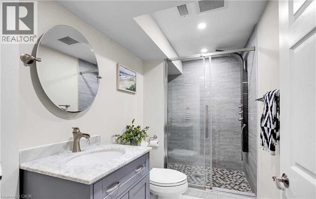 A bathroom with a white sink and a round mirror.