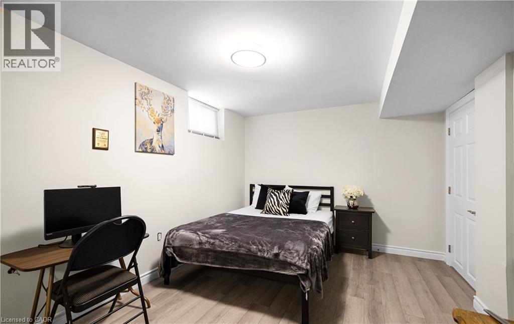 A bedroom with a bed, chair, and a painting on the wall.