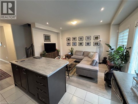 A living room with a grey sofa and a grey kitchen island.