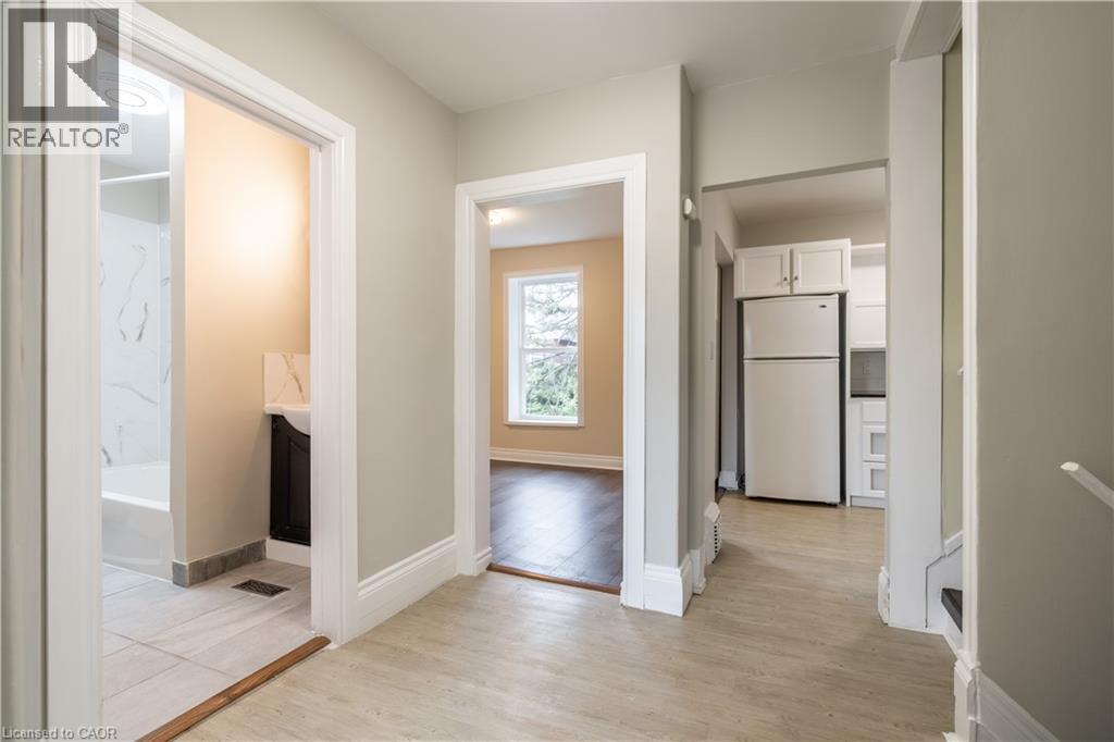 A spacious room with a window and a door leading to another room.