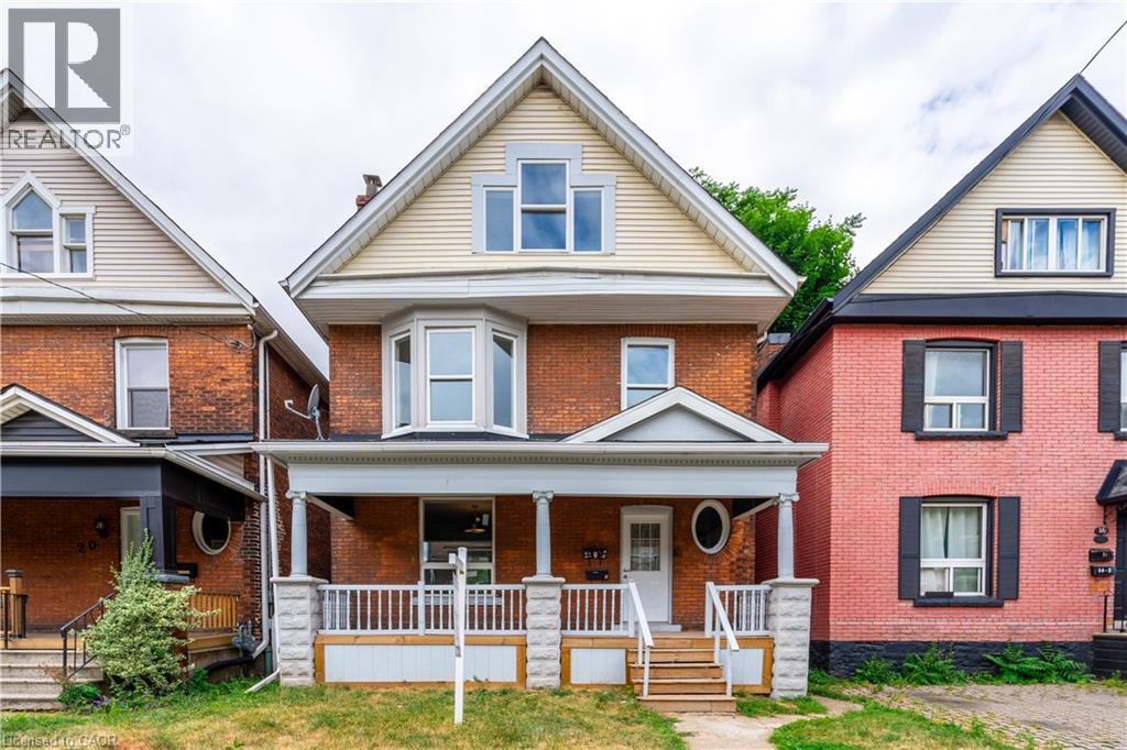 A house with a red brick exterior and a white porch.