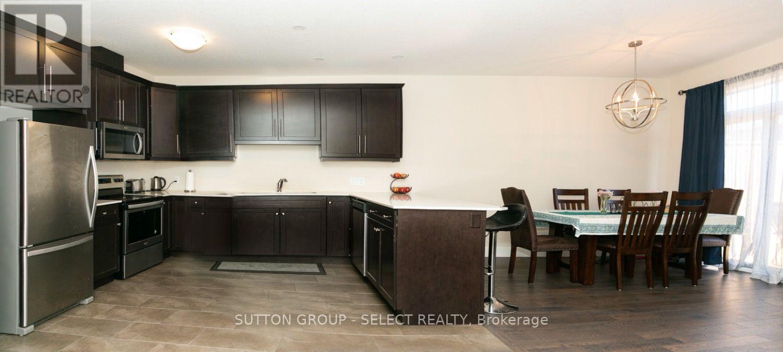 A kitchen with dark brown cabinets and a dining table with chairs.