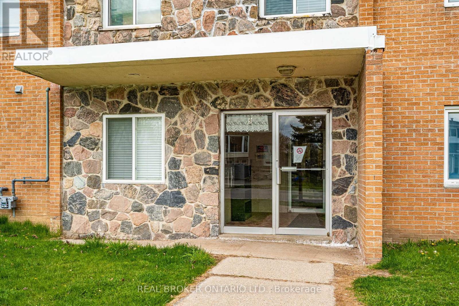 A stone building with a glass door and windows.