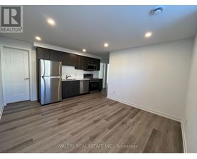 A kitchen with a refrigerator, microwave, and oven.