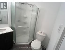 A bathroom with a toilet, sink, and shower.