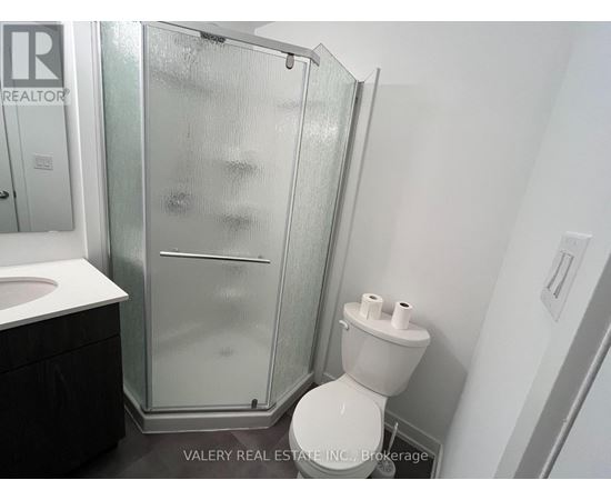 A bathroom with a toilet, sink, and shower.