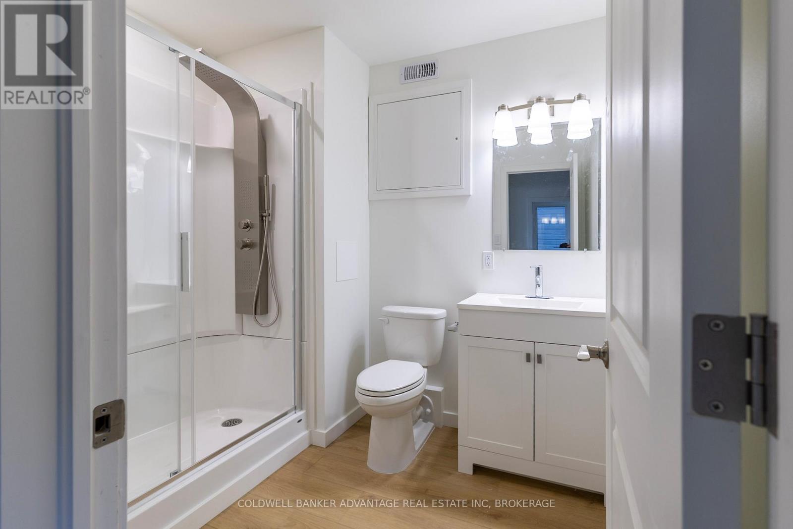 A white bathroom with a toilet, sink, and shower.