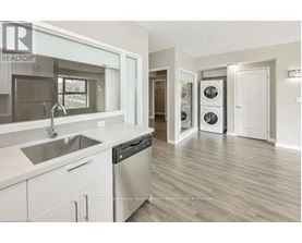 A modern kitchen with a sink, stove, and dishwasher.