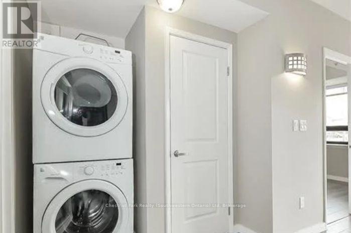 A white washing machine and dryer stacked on top of each other in a laundry room.