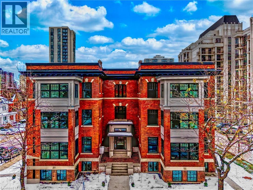 A red brick building with a glass window and a tree in front of it.