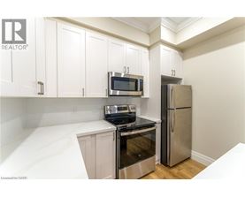 A kitchen with white cabinets and a stainless steel refrigerator.