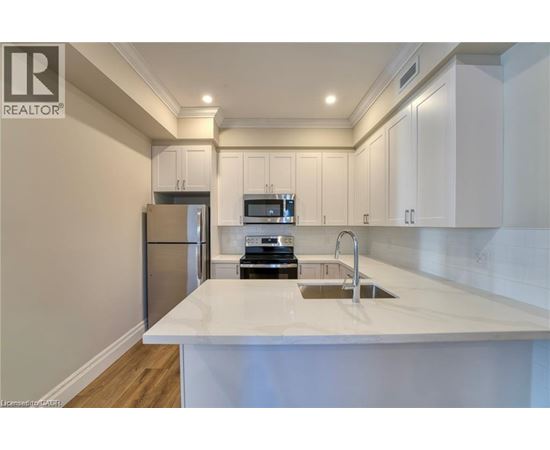 A modern kitchen with white cabinets and a white countertop.