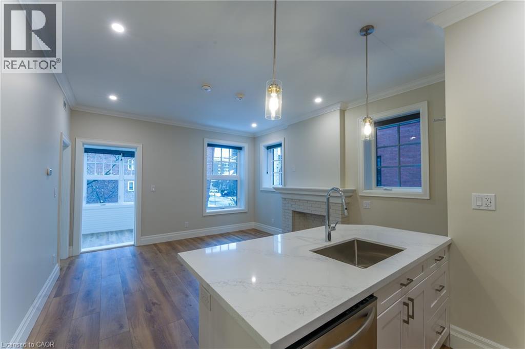 A modern kitchen with a large island and pendant lights.