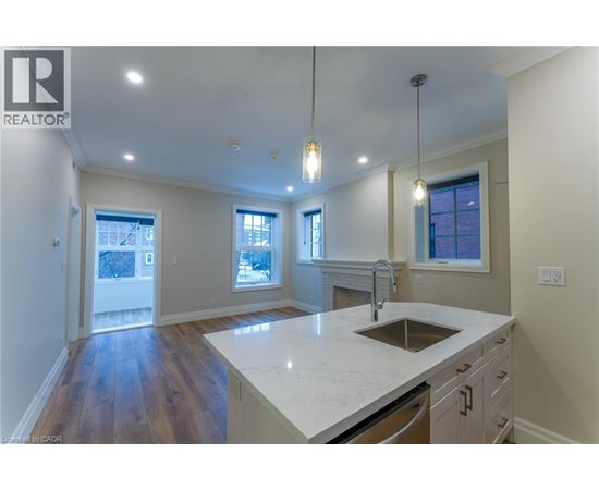A modern kitchen with a large island and pendant lights.