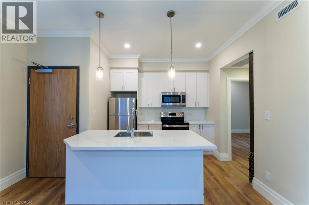 A modern kitchen with a white island and wooden floors.