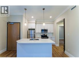 A modern kitchen with a white island and wooden floors.