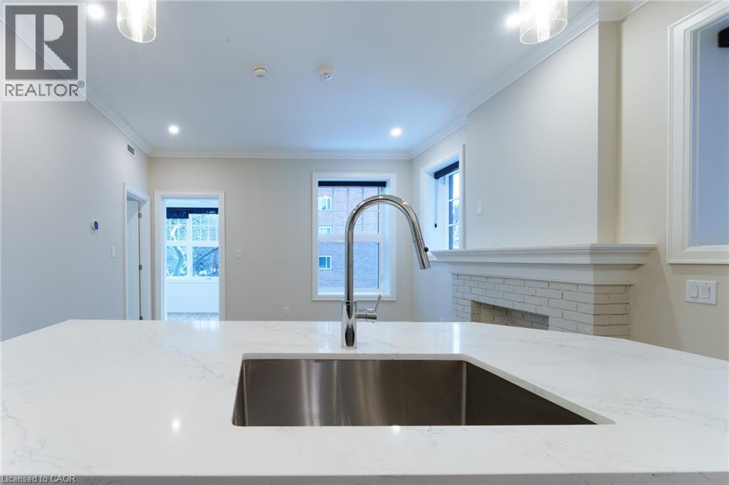 A modern kitchen with a stainless steel sink and white countertops.