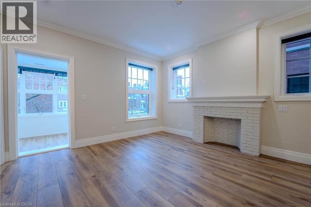 A spacious living room with a fireplace and hardwood floors.