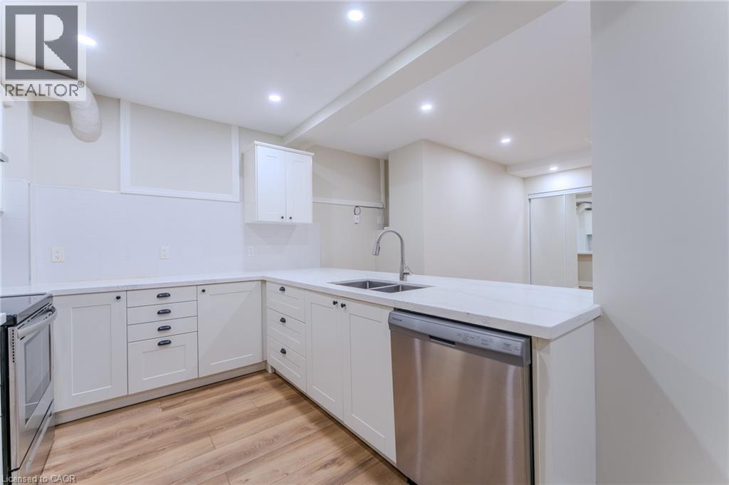 A modern kitchen with white cabinets and a stainless steel dishwasher.